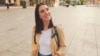 Omuzlarında sırt çantasıyla gezgin kız, Avrupa 'nın tarihi bölgesinde yürüyor.