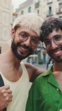 Homoseksüel çift karşılarında dikilip eski şehrin sokaklarında kameralara bakıyor.