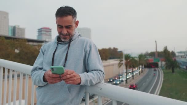Sonriente Hombre Mediana Edad Ropa Deportiva Usando Teléfono Móvil Mientras — Vídeo de stock