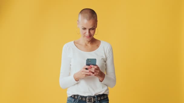 Mujer Joven Usando Teléfono Móvil Aislado Sobre Fondo Amarillo Estudio — Vídeo de stock