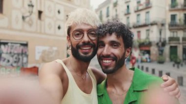Homoseksüel çift, eski şehrin sokaklarında birbirlerine sarılıp selfie çekiyorlar.