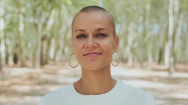 Yaklaş, güzel mutlu kadın gülümseyerek kameraya bakıyor.