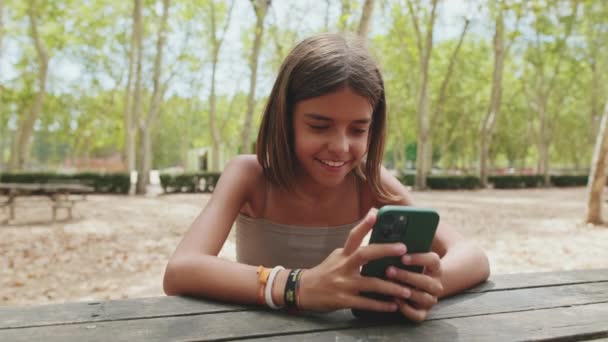 Feliz Adolescente Chica Mensajes Texto Teléfono Móvil Mientras Está Sentado — Vídeo de stock