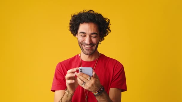 Homem Sorridente Usando Telefone Celular Digitando Massagens Isoladas Fundo Amarelo — Vídeo de Stock