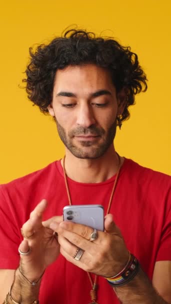Здивований Чоловік Вказує Індексний Палець Мобільний Ізольований Жовтому Тлі Студії — стокове відео
