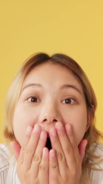 Zaskoczona Młoda Kobieta Zakrywa Usta Dłonią Klaszcząc Dłonie Odizolowane Żółtym — Wideo stockowe