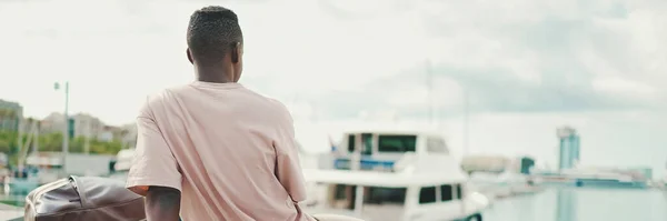 Νεαρός Αφρικανός Κάθεται Στο Ανάχωμα Φόντο Γιοτ Και Πλοία Πίσω — Φωτογραφία Αρχείου