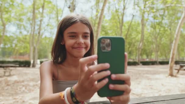Adolescente Chica Utiliza Teléfono Móvil Mientras Está Sentado Parque — Vídeo de stock