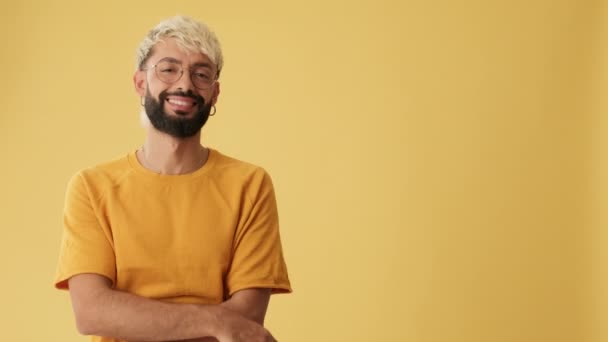 Usmívající Muž Ukazuje Prstem Reklamní Prostor Izolované Žlutém Pozadí Studiu — Stock video