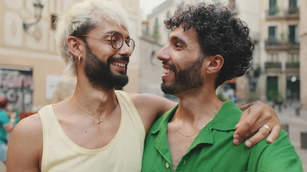 Homosexual couple stands hugging and takes selfie on street of old city