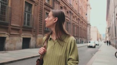 Bir Avrupa şehrinin caddesinde yürüyen genç bir kadın