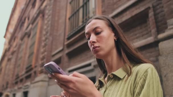 ヨーロッパの街の通りに携帯電話を使用して若い女性のクローズアップ — ストック動画