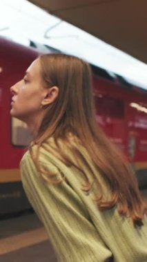 Tren istasyonunda trene binen genç bir kadın.