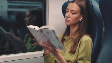 Trende kitap okuyan genç bir kadın.