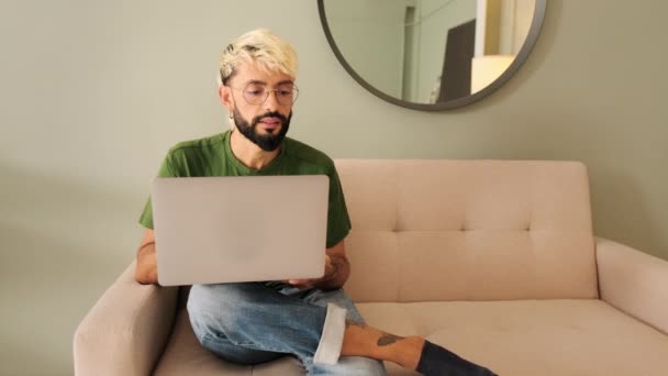 Egy Fiatal Szakállas Szőke Férfi Laptopon Dolgozik Miközben Egy Kényelmes — Stock videók