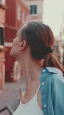 Dikey video, Venedik 'te yürüyen genç kadın turist, ileri doğru hareket eden kamera