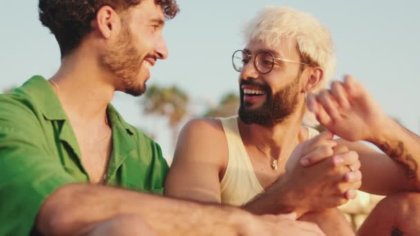 Yaklaşın Genç Eşcinsel Çift Kumsalda Otururken Kollarını Kavuşturuyorlar — Stok video