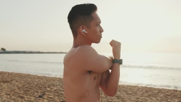 Junger Athletischer Mann Steht Strand Beim Aufwärmen — Stockvideo