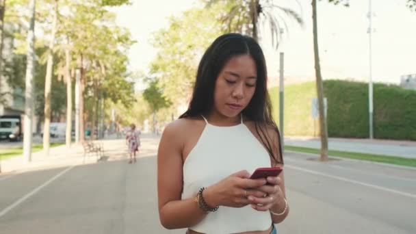 Beautiful Young Woman Walks Street Modern City Uses Mobile Phone — Stock Video