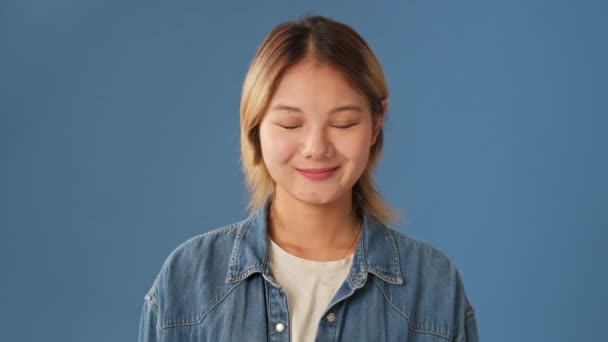 Młoda Kobieta Podnosi Głowę Otwiera Oczy Patrząc Kamerę Niebieskim Tle — Wideo stockowe
