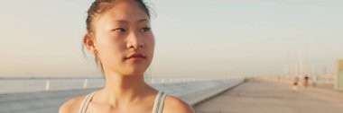 Spor tişörtlü Asyalı kız sabah vakti dışarıda yürüyor, Panorama