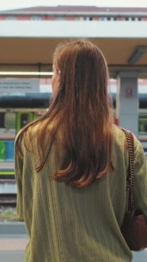 Tren istasyonunda bankta oturan genç bir kadın yaklaşan bir tren geçmişiyle