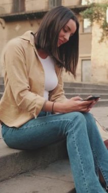 Kadın gezgin, eski Avrupa şehrinin tarihi bölümünde cep telefonu kullanıyor