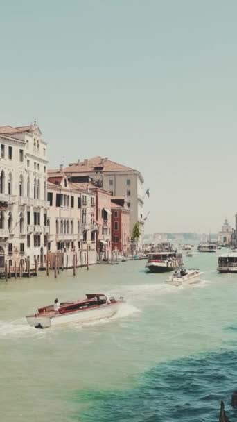 在阳光明媚的日子里 威尼斯运河 小船和带着游客的贡多拉的垂直录像沿着运河漂浮着 — 图库视频影像