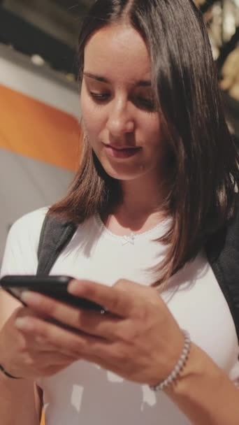 Genç Bir Kadın Elinde Cep Telefonuyla Tren Istasyonunun Platformu Boyunca — Stok video