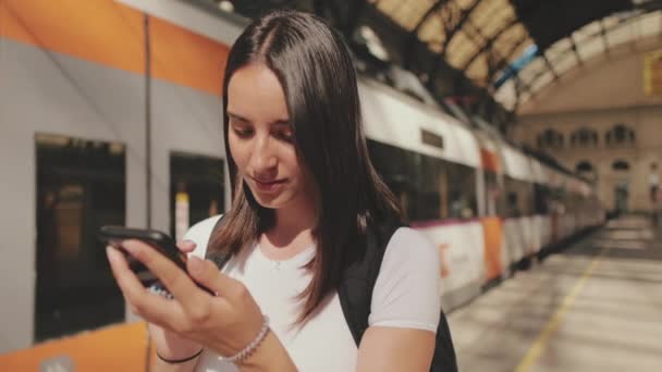 Yaklaş Genç Bayan Tren Istasyonunun Platformunda Dururken Cep Telefonunu Kaydırıyorsun — Stok video