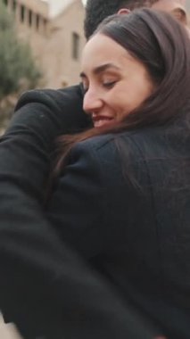 Bulutlu bir günde katedralin önünde kucaklaşan genç çift.