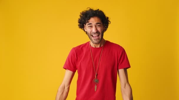 행복한 남자는 스튜디오에서 노란색 배경에 카메라를 승리를 — 비디오
