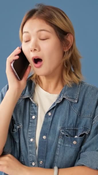 Überraschte Junge Frau Telefoniert Isoliert Auf Blauem Hintergrund — Stockvideo