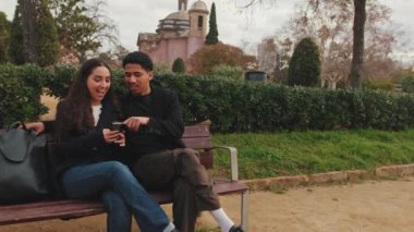 Açık havada akıllı telefonlara bakan genç bir çift..