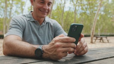 Cep telefonu tutan orta yaşlı bir adamın elleri yakın plan bulanık