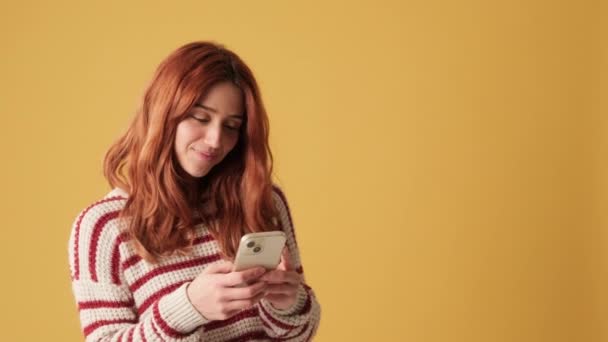 Χαμογελαστό Κορίτσι Που Χρησιμοποιεί Κινητό Τηλέφωνο Κίτρινο Φόντο — Αρχείο Βίντεο