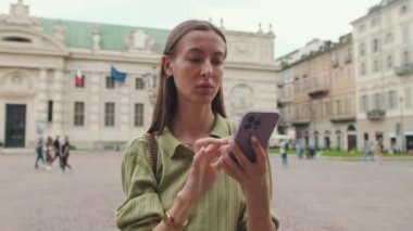 Kasaba meydanında telefon kullanan genç bir kadın.