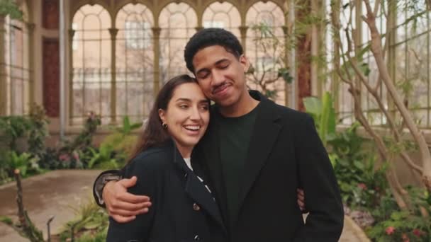 快乐的年轻夫妇拥抱在温室里 — 图库视频影像