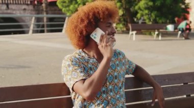 Açık havada telefonla konuşan erkek öğrencinin portresi.