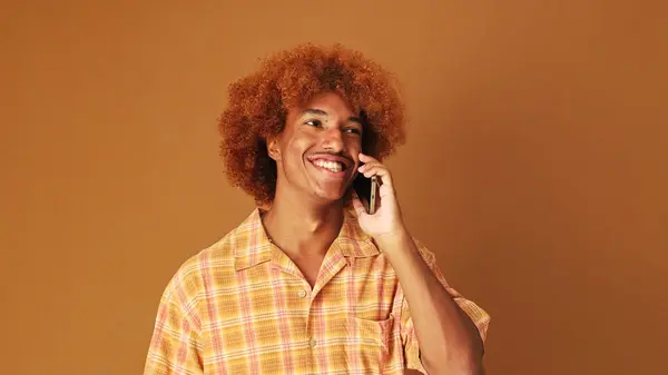 Sonriente Chico Rizado Con Estilo Habla Emocionalmente Teléfono Móvil Aislado — Foto de Stock