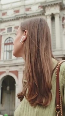 Kablosuz kulaklıklı genç kadın İtalya 'da seyahat ediyor.