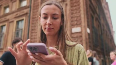 Yaklaş, genç bayan. Avrupa 'da bir şehrin caddesinde telefon kullanıyorsun.