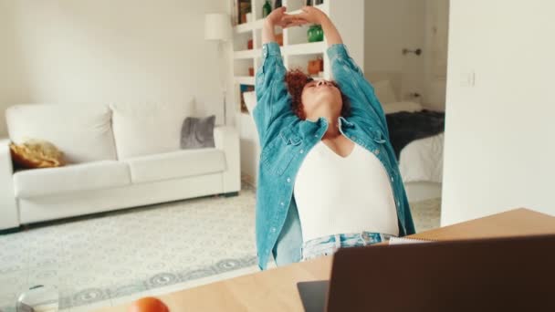Жінка Ноутбуком Сидячи Столом Розтягує Руки Дивлячись Сторону Вдома — стокове відео
