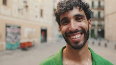 Yaklaş, sakallı, tatlı esmer adam başını çeviriyor ve kameraya bakarken gülümsüyor.