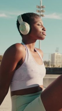 Kaykay parkında takılan kulaklıklı kız sporcunun yakın görüntüsü.