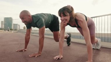 Mutlu çoklu etnik çiftlerin yakın çekimi açık havada antrenman yapıyor, dışarıda Crossfit yapıyor.