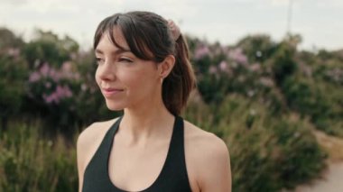 Avrupa 'nın yakından bakan yüzü, spor giyim kuşamında parka ve ağaçlara karşı gülümseyen kız, sağlıklı kadın portresi