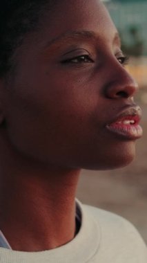 Kızın yakın çekimi deniz manzarasına karşı derin bir nefes alır.