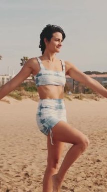 Sahilde yoga yapan bir kız, deniz kenarında yoga dersi alan bir kız.