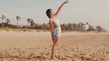 Plajda yoga yapan genç bir kadının portresi, zarif bir bayan atlet.